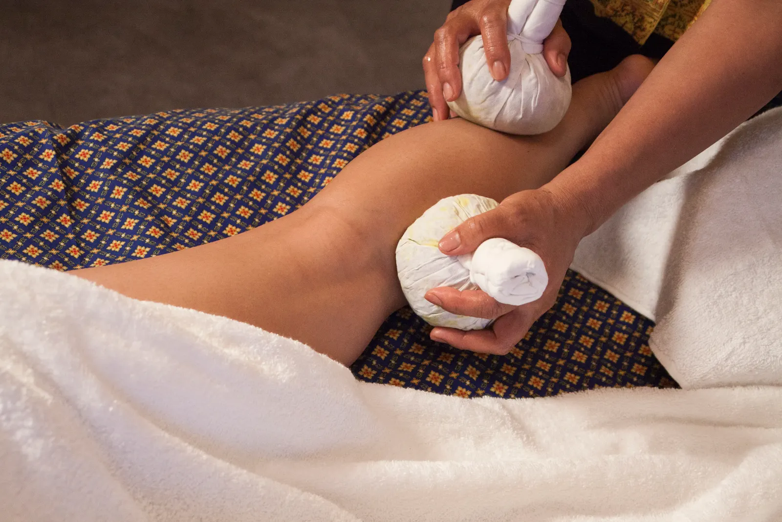 Warme kruidenkompres massage